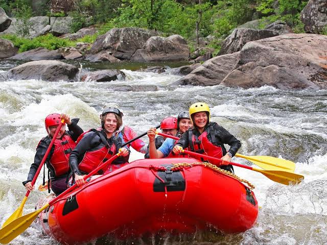 A raft of North Creek guests paddle warm summer whitewater on the Hudson River