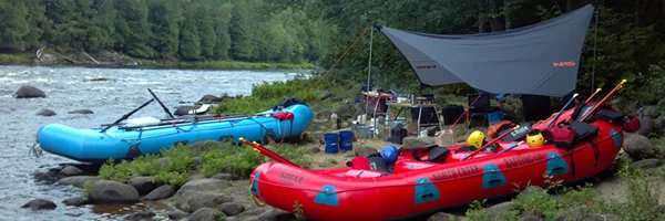 North Creek rafts beside a riverside campsite in the forested Hudson River Gorge